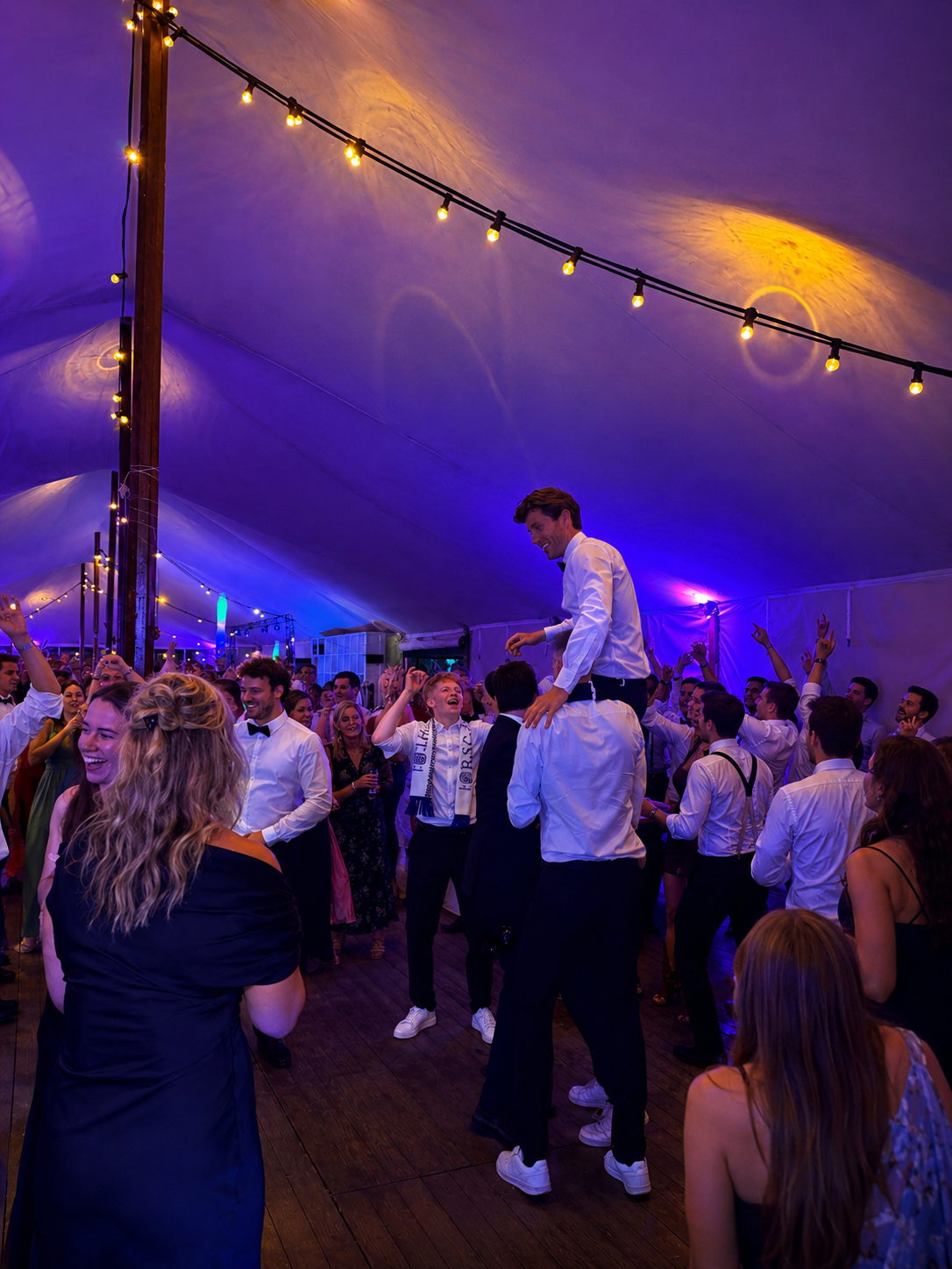 Feesttent met sfeerverlichting en volle dansvloer